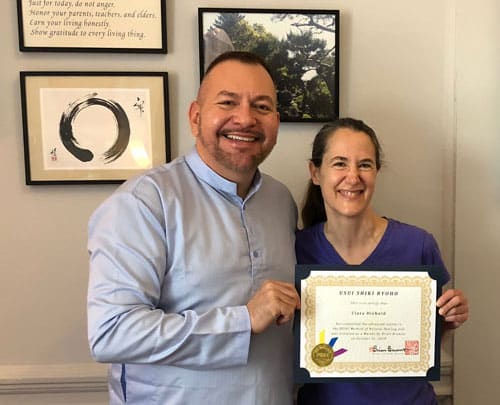 Photo of Clara Diebold receiving her Reiki Master Certificate from Brian Brunius of the NYC Reiki Center