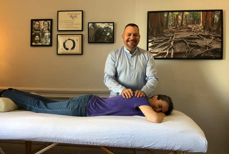 Photo of Clara Diebold receiving a Reiki treatment from her initiating Master Brian Brunius on the day of her Reiki Master initiation