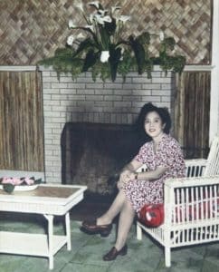 Photo of Hawayo Takata sitting next to a fireplace in 1951