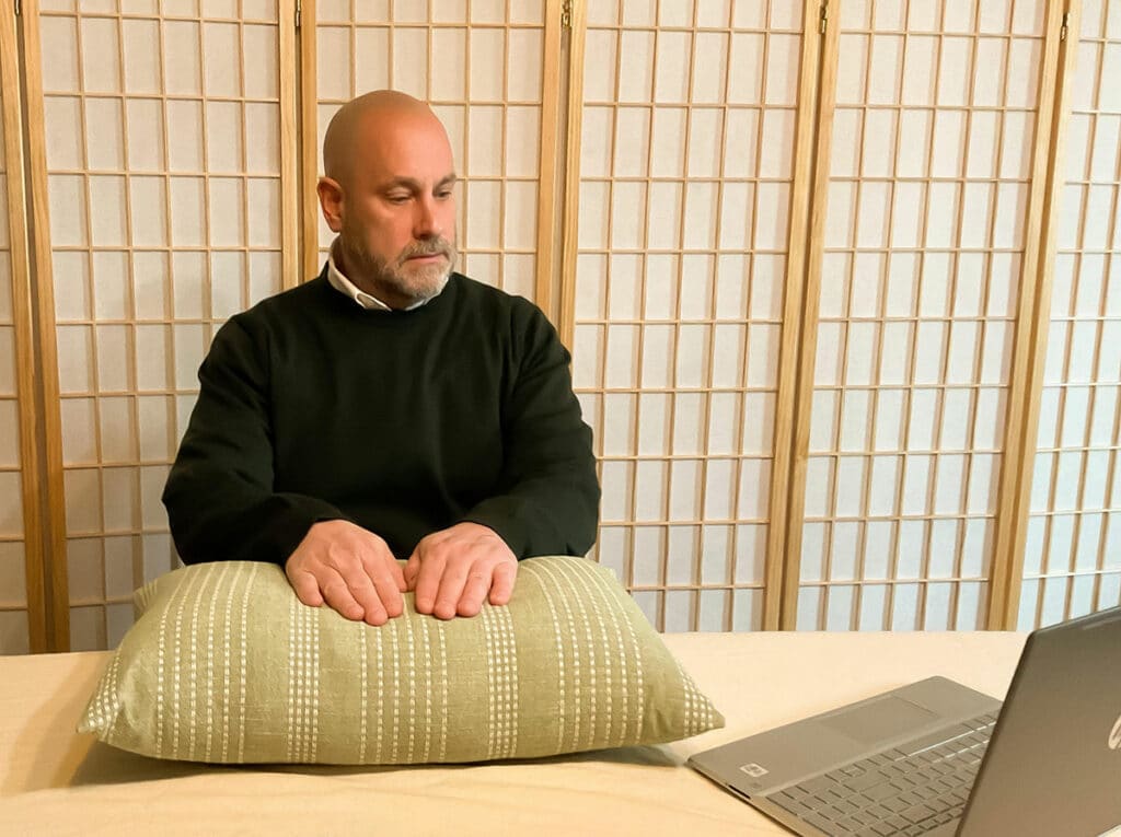 Photo of Mark Straubel talking on Zoom to a client and delivering a Virtual Reiki Treatment