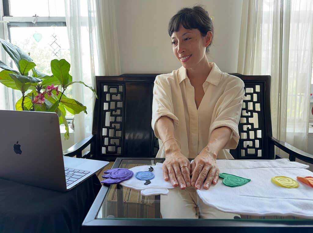 Photo of Vanessa Gomez talking on Zoom to a client and delivering a Virtual Reiki Treatment