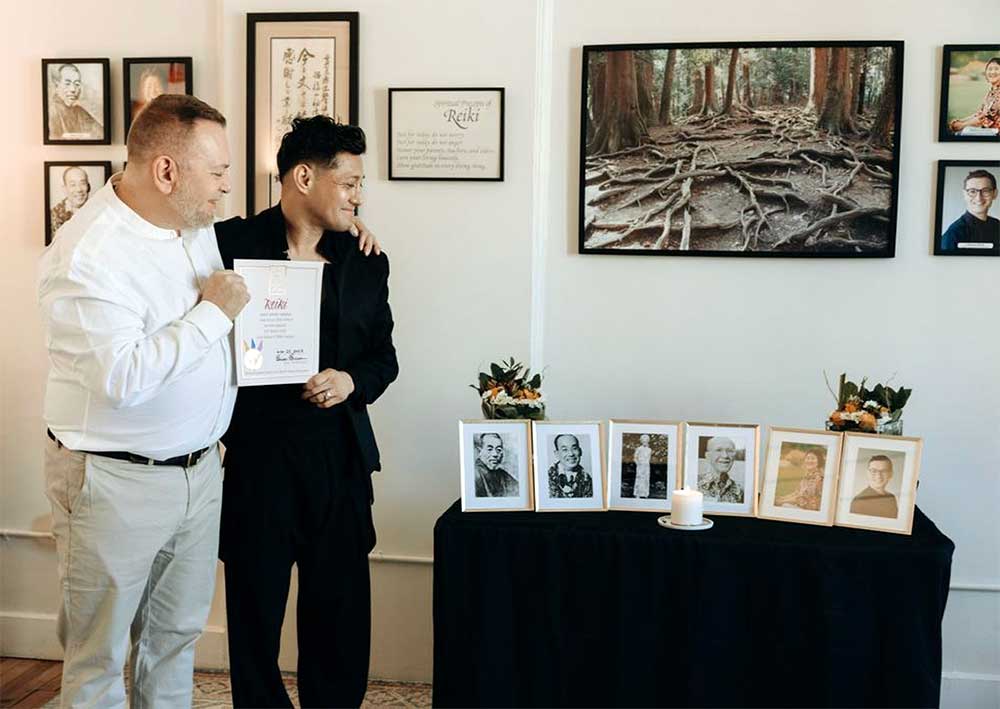 Photo of newly-initiated Reiki Master, Amilyo Escobar, on November 25, 2023. In this photo, Brian Brunius and Amilyo hold his Reiki Master certificate.